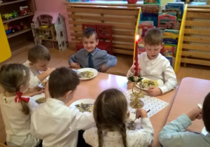 dzieci jedzą uroczysty obiad