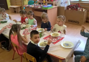 dzieci jedzą uroczysty obiad