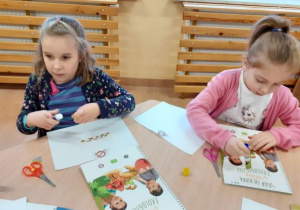 dziewczynki przyklejają na kardkę piramidę