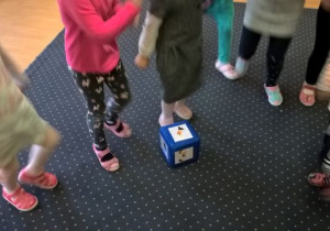 dzieci wykonują ćwiczenia ruchowe zgodne z wyrzuconym obrazkiem na kostce