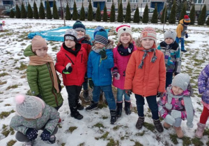 dzieci bawią sie śniegiem na przedszkolnym placu