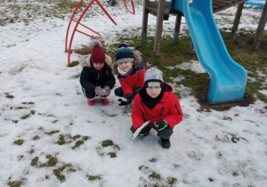 dzieci bawią sie śniegiem na przedszkolnym placu