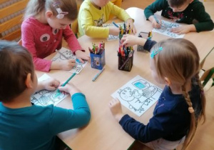 dzieci kolorują przy stoliku