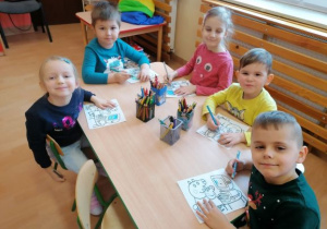 dzieci kolorują przy stoliku