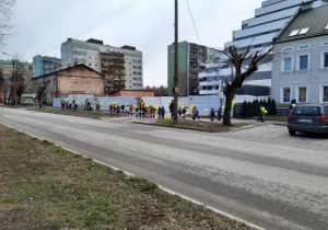 dzieci z zielonymi balonikami spacerują ul. Mickiewicza