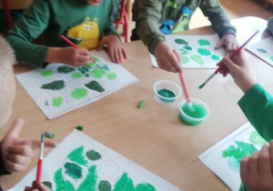 dzieci wykonują pracę plastyczną na temat zielonych roślin