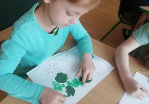 dzieci wykonują pracę plastyczną na temat zielonych roślin