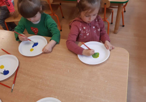 dzieci mieszają kolory, uczą się jak powstaje kolor zielony