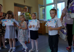 dzieci trzymają w rękach pamiątkowe dyplomy