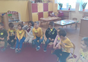 dzieci siedzą w kręgu z nauczycielką