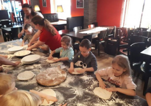 dzieci formują ciasto na pizzę
