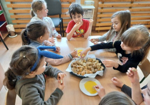 dzieci degustują chleb z miodem