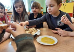 dzieci degustują chleb z miodem