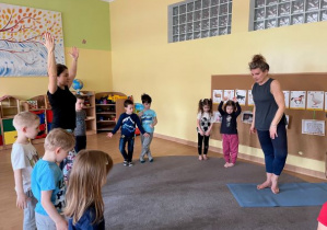 dzieci wykonują pozycje jogi zaproponowane przez instruktorkę