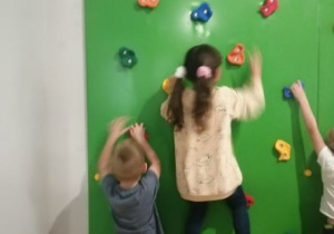 dzieci chodzą po ściance wspinaczkowej