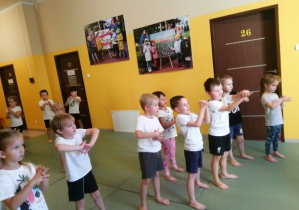 dzieci wykonują ćwiczenia na matach podczas zajęć z judo
