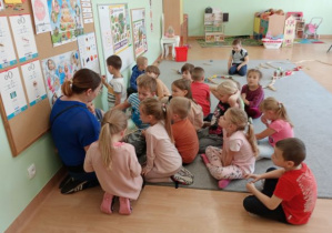 dzieci słuchają bajki "czerwony Kapturek", którą czyta mama Zosi