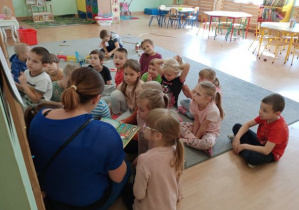 dzieci słuchają bajki "czerwony Kapturek", którą czyta mama Zosi