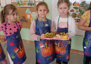 dzieci trzymają tace z owocami