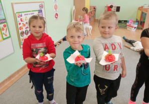 dzieci pokazują swoje owoce wykonane z masy solnej