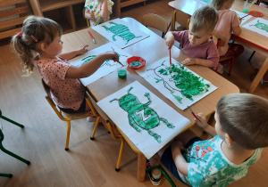 Dzieci malują zielona farbą.