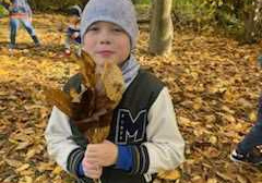 Chłopiec trzyma liście.