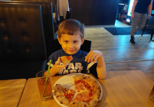 chłopiec je pizzę