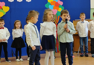 Chłopcy i dziewczynka mówią przez mikrofon
