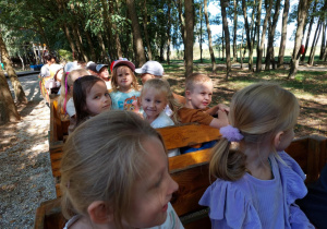 dzieci jadą w drewnianych wagonikach