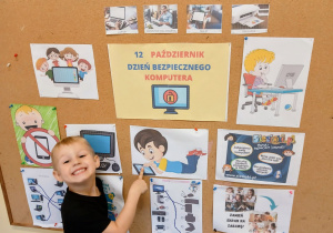 Chłopiec stoi przed tablicą.