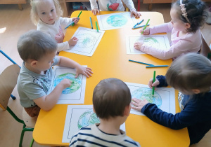 Dzieci kolorują model ziemi.