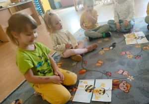 Dziewczynka układa obrazek z części.