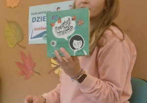 Pani trzyma książkę.