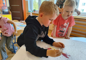 Chłopiec maluje.