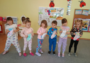 Dzieci stoją trzymają w ręku skarpetki.