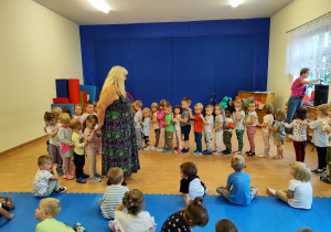Dzieci stoją ustawione w "pociąg"'.