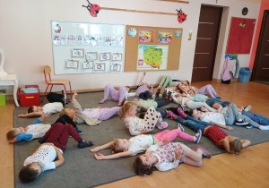 Dzieci leżą na dywanie.