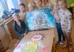 Przedszkolaki trzymają kolorowy plakat.