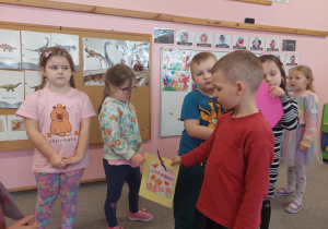 Chłopiec wręcza dziewczynce laurkę.