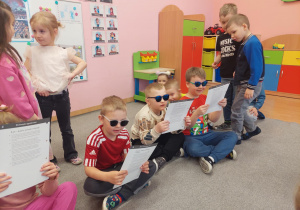 Dzieci oglądają przez niebieskie okulary.