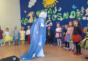 Kobieta w stroju Pani Zimy trzyma srebrny brokat.