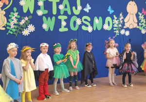 Grupa przedszkolaków stoi na scenie.