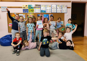 Przedszkolaki na dywanie pozyją do zdjęcia.