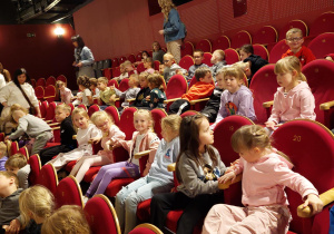 Przedszkolaki siedzą na widowni w teatrze.