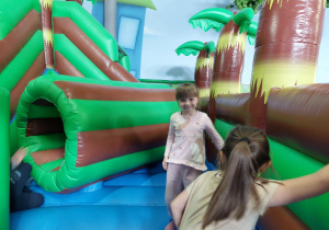 Dzieci skaczą na dmuchańcu.