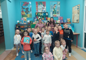 Przedszkolaki uśmiechając się pozują do zdjęcia.