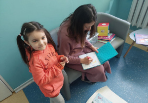 Dziewczynka uśmiechając się czeka na autograf.