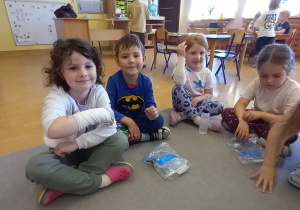 Uśmiechnięta dziewczynka bandażuje rękę.