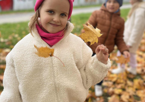 Mała dziewczynka trzyma jesienny liść.