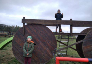 Chłopcy bawią się na drewnianej przyczepie.